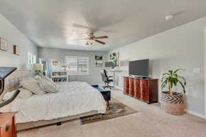 Carpeted bedroom with ceiling fan and a textured ceiling