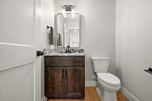 Bathroom featuring vanity, toilet, and hardwood / wood-style floors