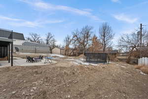 View of yard featuring a patio and a trampoline