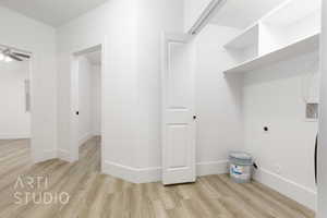 Clothes washing area featuring ceiling fan, light wood-type flooring, and electric dryer hookup