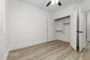 Unfurnished bedroom featuring ceiling fan, a closet, and light wood-type flooring