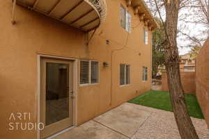 View of property exterior featuring a patio area and a lawn