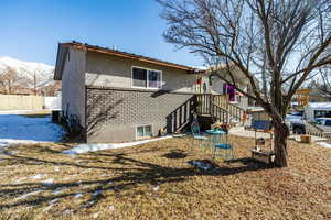 Rear view of property featuring a mountain view and central air condition unit