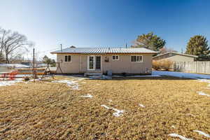 Rear view of property with a yard and french doors