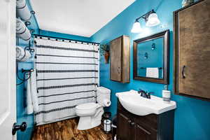 Bathroom featuring wood-type flooring, vanity, and toilet