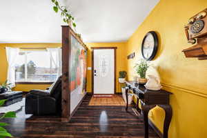 Entryway with dark hardwood / wood-style flooring.