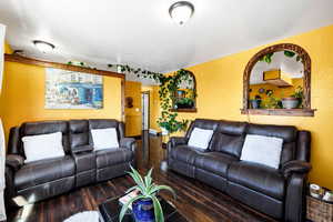 Living room with arched windows to dining.