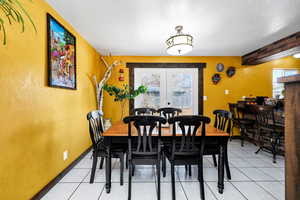 Dining room with french doors, a healthy amount of sunlight, and light tile patterned floors