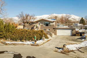 View of front of property with a garage and a mountain view