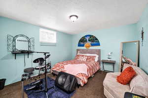 Bedroom 4. Carpeted bedroom with a textured ceiling