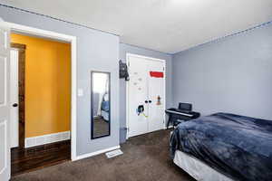 Bedroom 2 featuring a textured ceiling and dark-colored carpet