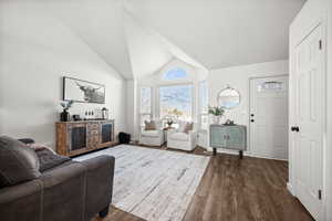 Living room featuring dark hardwood / wood-style flooring and vaulted ceiling