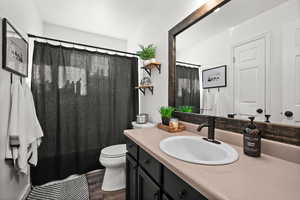 Bathroom featuring vanity, toilet, and hardwood / wood-style floors