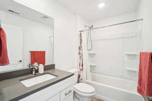 Full bathroom with vanity, toilet, and shower / bath combo with shower curtain