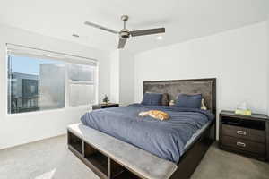 Carpeted bedroom featuring ceiling fan