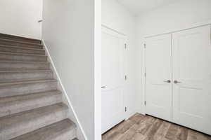 Staircase featuring hardwood / wood-style flooring