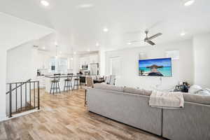 Living room with light hardwood / wood-style floors and ceiling fan