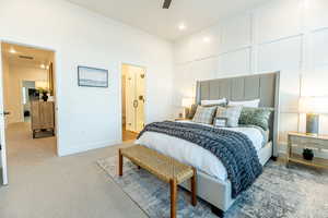 Carpeted bedroom featuring ensuite bathroom and ceiling fan