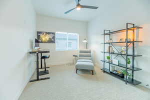 Sitting room featuring ceiling fan and carpet flooring