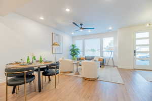 Dining space with ceiling fan and light hardwood / wood-style floors