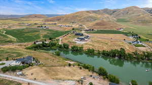 Drone / aerial view with a water and mountain view and a rural view