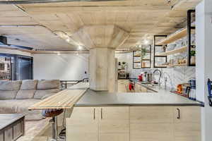 Kitchen with tasteful backsplash, sink, stainless steel range with electric cooktop, and rail lighting