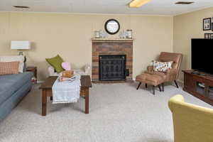 Living room with a brick fireplace and carpet