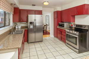 Kitchen with sink, light tile patterned floors, and stainless steel appliances