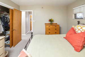 Carpeted bedroom with a closet