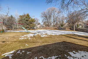 Yard layered in snow with a playground