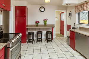 Kitchen featuring stainless steel range with electric cooktop and light tile patterned floors