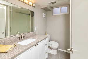 Bathroom with vanity, hardwood / wood-style flooring, and toilet