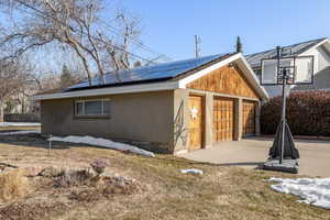 View of home's exterior with a garage and solar panels