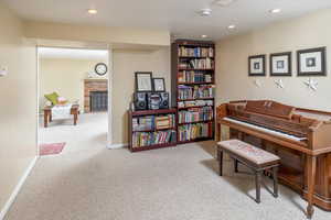 Misc room featuring a brick fireplace and light carpet