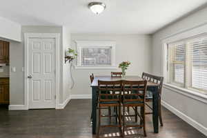 Dining space with dark wood-type flooring and a textured ceiling