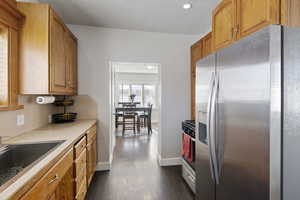 Kitchen featuring dark wood-type flooring, stainless steel appliances, sink, and decorative backsplash