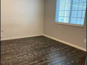 Empty room featuring dark hardwood / wood-style floors