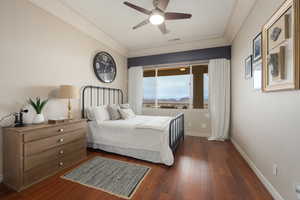 Bedroom with crown molding, dark wood-type flooring, and ceiling fan