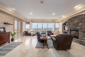 Living room featuring a stone fireplace and light tile patterned floors