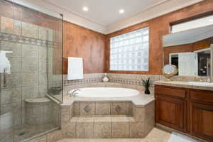 Bathroom featuring tile patterned floors, vanity, and separate shower and tub