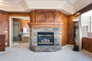 Living room with a stone fireplace and light colored carpet