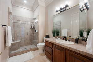 Bathroom with tile patterned floors, toilet, an enclosed shower, crown molding, and vanity