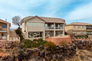 Back of property with a balcony and a patio area