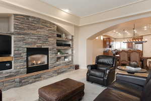 Living room featuring a tray ceiling, a fireplace, and built in features