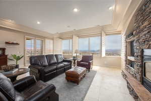 Living room featuring a stone fireplace and light tile patterned floors