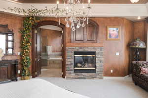 Bedroom with a fireplace and a chandelier