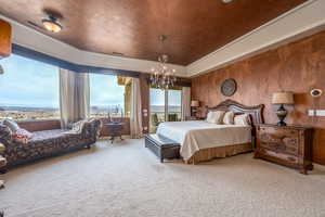 Carpeted bedroom featuring an inviting chandelier and access to exterior