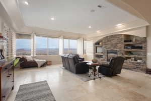 Living room featuring a stone fireplace and built in shelves