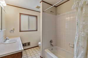 Full bathroom with shower / bath combination with curtain, vanity, ornamental molding, toilet, and a textured ceiling