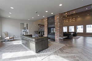 Living room featuring an inviting chandelier, a textured ceiling, and light parquet flooring